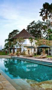 a swimming pool in front of a house at Avillion Villa Cinta @Sanur, Bali in Sanur
