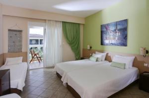a hotel room with two beds and a balcony at Alexandra Beach Spa Resort in Potos