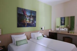 a hotel room with two beds and a desk at Alexandra Beach Spa Resort in Potos