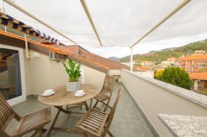 un piccolo balcone con tavolo e sedie in legno di Residenza Adelaide a Finale Ligure