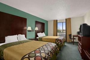 a hotel room with two beds and a flat screen tv at Quality Inn in Jackson