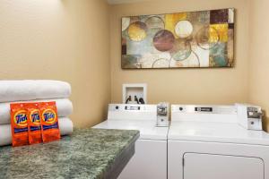 eine Waschküche mit Waschmaschinen und einem Gemälde in der Unterkunft Super 8 by Wyndham Coeur d'Alene in Coeur d'Alene