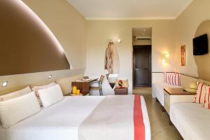 a hotel room with two beds and a couch at Alexandra Beach Spa Resort in Potos