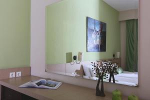 a mirror in a room with a bed and a table at Alexandra Beach Spa Resort in Potos