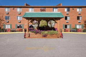 a wooden gazebo with flowers in front of a building at Super 8 by Wyndham Jackson Hole in Jackson