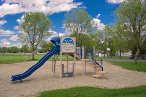 a playground with a blue slide in a park at Super 8 by Wyndham Willmar in Willmar