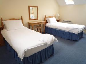 En eller flere senge i et værelse på Ardamine Holiday Homes