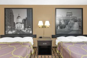a hotel room with two beds and two pictures at Super 8 by Wyndham Terre Haute in Terre Haute