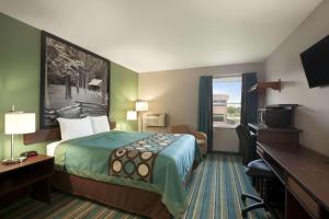 a hotel room with a bed and a desk at Super 8 by Wyndham Tuscola in Tuscola