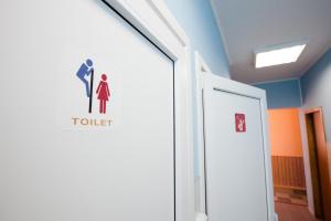 a door in a hospital with a toilet sign on it at Pilgrim Hostel in Ivano-Frankivsk