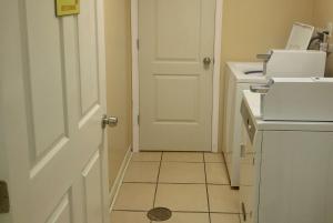 a bathroom with a white door and a tile floor at Super 8 by Wyndham Dover in Dover