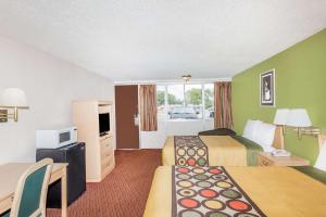 a hotel room with two beds and a television at Knights Inn Statesboro in Statesboro