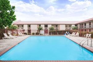 a large swimming pool with chairs and a building at Super 8 by Wyndham Oxford in Oxford