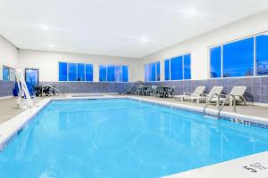 a swimming pool with blue water in a building at Howard Johnson by Wyndham Perry GA in Perry
