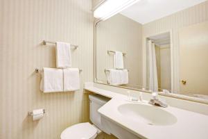 a white bathroom with a white toilet and sink at Travelodge by Wyndham Seattle By The Space Needle in Seattle