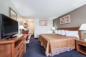 a hotel room with a bed and a flat screen tv at Red Carpet Inn Lancaster in Lancaster