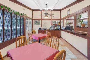 a dining room with tables and chairs and a kitchen at Knights Inn - Battle Creek in Battle Creek