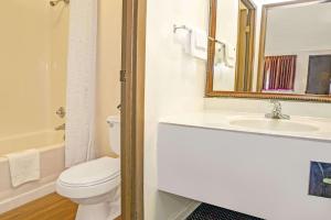 a bathroom with a toilet and a sink and a mirror at Guest Inn Lebanon (Ohio) in Lebanon