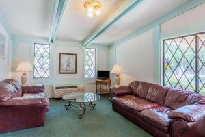 a living room with leather furniture and stained glass windows at Sunrise Inn in Elkton
