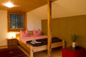 Schlafzimmer mit Himmelbett und rosa Kissen in der Unterkunft Waldhütte in Hochpillberg