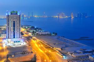 Una vista de una ciudad de noche con luces de la calle. en Retaj Al Rayyan, en Doha