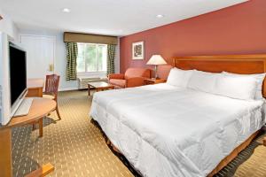 a hotel room with a bed and a flat screen tv at Knights Inn Indianapolis in Indianapolis
