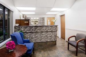 a waiting room with blue chairs and a table at Knights Inn Pittston in Pittston