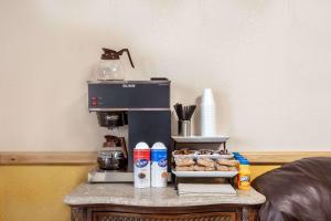 a coffee maker sitting on top of a table with pastries at Knights Inn Wildersville in Wildersville