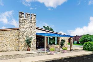 a stone building with a blue awning at Knights Inn Indianapolis in Indianapolis