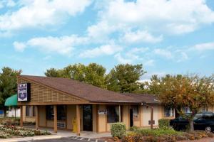 a building with a car parked in a parking lot at Knights Inn Martinsburg in Martinsburg