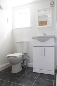 1BD Apartment in Dalston في لندن: حمام ابيض مع مرحاض ومغسلة
