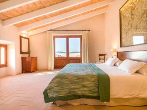 a bedroom with a large bed and a large window at Agroturisme Gossalba in Sant Joan