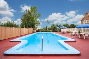 a swimming pool in a yard with a fence at Travelodge by Wyndham South Burlington in Burlington