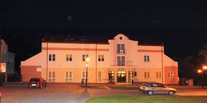 un grande edificio bianco con auto parcheggiate di fronte di Centrum Ostra Brama im. Jana Pawła II a Skarżysko-Kamienna