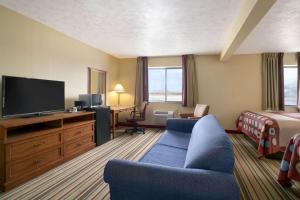 a hotel room with a bed and a television at Super 8 by Wyndham Park City/North Wichita Area in Park City