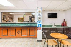 a bar in a room with a table and chairs at Super 8 by Wyndham Greensboro in Greensboro