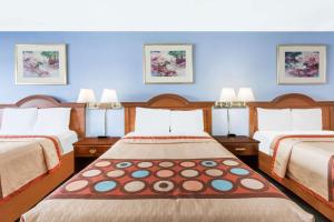 En eller flere senge i et værelse på Super 8 by Wyndham Greensboro