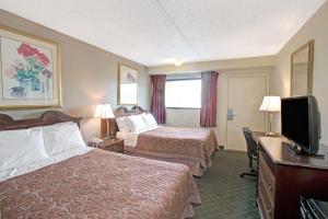 a hotel room with two beds and a flat screen tv at Super 8 by Wyndham Shelby in Shelby