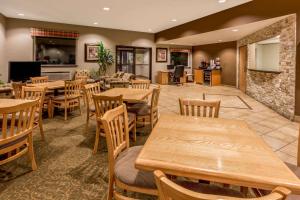 a restaurant with wooden tables and wooden chairs at Super 8 by Wyndham Woodburn in Woodburn