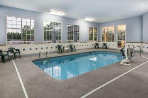 a large swimming pool in a building with windows at Super 8 by Wyndham Fayetteville in Fayetteville