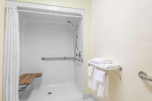 a bathroom with a shower and white towels at Super 8 by Wyndham Fayetteville in Fayetteville