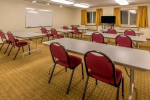 uma sala de aula com mesas e cadeiras e um quadro branco em Super 8 by Wyndham Woodburn em Woodburn