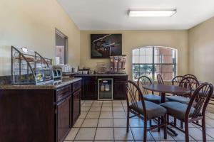 a kitchen with a table and chairs and a dining room at Super 8 by Wyndham Greenville in Greenville