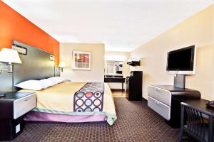 a hotel room with a bed and a flat screen tv at Super 8 by Wyndham Kissimmee/Maingate/Orlando Area in Orlando