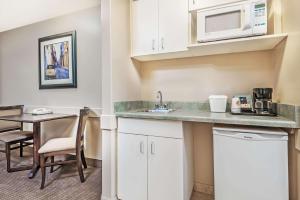 uma cozinha com um lavatório e uma mesa com um micro-ondas em Super 8 by Wyndham Edmonton South em Edmonton