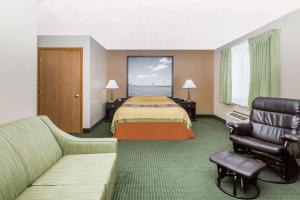 a hotel room with a bed and a couch at Super 8 by Wyndham Jefferson in Jefferson