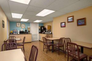 a waiting room with tables and chairs and a kitchen at Super 8 by Wyndham Austin Downtown/Capitol Area in Austin