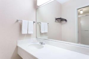 a white bathroom with a sink and a mirror at Travelodge by Wyndham San Francisco Airport North in South San Francisco