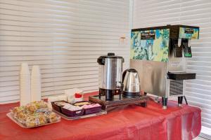 un tavolo con macchinetta del caffè e cibo sopra di Sunset Inn Historic District St. - St. Augustine a St. Augustine