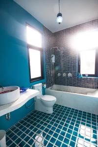 Baño azul con aseo y bañera en Laemsing Whitehouse Resort, en Laem Sing